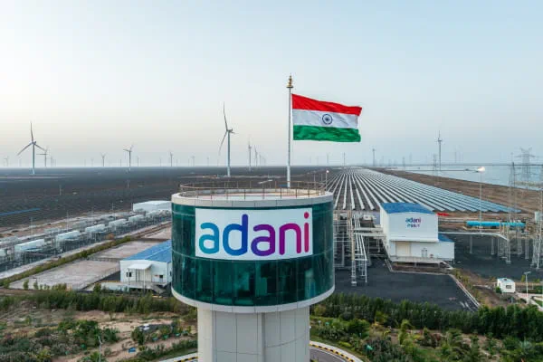 Control room operators monitoring grid integration of Adani Green Energy's Khavda BESS facility, with dashboards showing renewable energy firming, battery state-of-charge, and grid dispatch schedules.