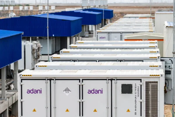 Battery energy storage system container units arranged in rows at Adani Green Energy's Khavda park in Gujarat, representing India's largest BESS installation outside China at 3.37 GWh.