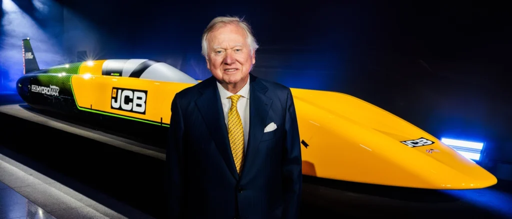 Lord Bamford standing beside JCB Hydromax hydrogen landspeed record car